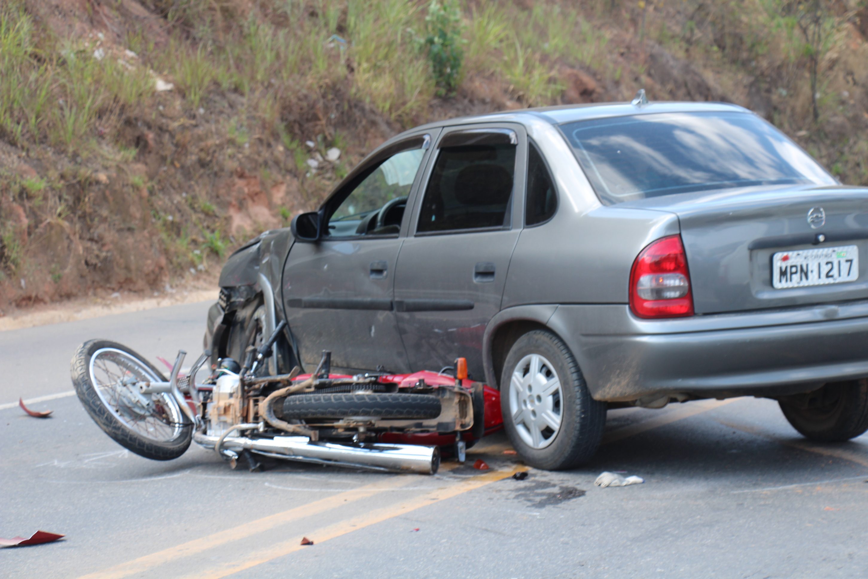 Motociclista é arremessado após moto colidir contra automóvel